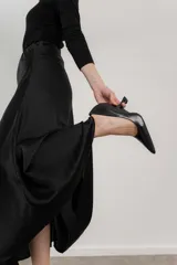 Zapato de cuero color beige con punta fina y taco de forma geométrica.