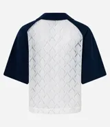 Remera de encaje blanco con mangas cortas raglán azul marino, cuello en V y estampado frontal con la inscripción "Kansas League Est. 1995".