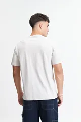 Remera gris de manga corta con cuello redondo y estampado tipográfico en el frente.