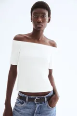Top blanco de punto pesado, con escote off-the-shoulder y mangas cortas.