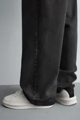 Zapatillas deportivas negras con detalle en blanco en el talón y suela blanca con volumen.