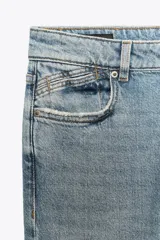Pantalón de jean azul oscuro, de tiro bajo, corte slim fit y bootcut. Con cinco bolsillos y cierre frontal con cremallera y botón.