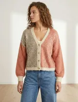 Cardigan de punto con escote en V y abotonadura frontal. Presenta un diseño colorblock con paneles en beige claro, rosa salmón y beige con lentejuelas dispersas. Las mangas son largas y abullonadas con puños y ruedo en punto acanalado beige claro.
