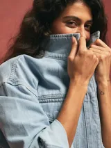 Sobrecamisa celeste de denim con bolsillos frontales y corte holgado.