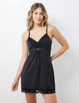 Chemise negra con breteles finos regulables y apliques de encaje en escote y ruedo.