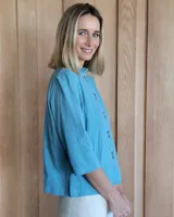 Camisa color beige claro con cuello con volados y mangas 3/4 abullonadas.