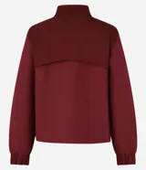 Campera deportiva rompevientos color bordó, con cuello alto, cierre frontal con cremallera, puños elastizados y recortes con hilo reflectante.