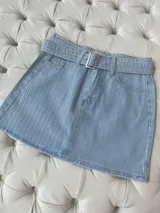 Minifalda de jean celeste con rayas verticales de strass y cinturón con hebilla metálica.