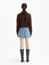 Minifalda de cuero ovino color azul, con terminación símil denim. Cuenta con bolsillos plaqué en la parte trasera y remaches tipo jeaneros. El acceso es mediante cierre y botón metálico.