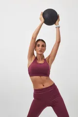 Top deportivo color verde militar con espalda cruzada en cuatro tiras y almohadillas removibles.