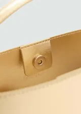 Bolso mini tipo bucket plateado, con asa de mano rígida y correa bandolera fina ajustable.