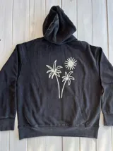 Hoodie negro con capucha, corte oversize y puños ajustados. Estampado en la espalda con dos palmeras y un sol.