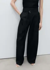 Pantalón wide leg negro de tiro alto con trabillas, cierre frontal con botón, gancho y cremallera, cinturón con hebilla, dos bolsillos laterales, pinzas delanteras y diseño largo.