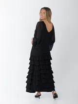 Falda larga negra con cintura elástica y múltiples volados horizontales.