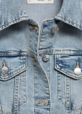 Chaqueta de jean celeste claro, con cuello clásico, cierre frontal con botones, dos bolsillos de parche en el pecho y dos bolsillos laterales.