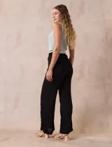 Pantalón negro de rayón con bordados florales, pretina ancha elastizada en punto smock y corte palazzo. Marca Liv Los Angeles.