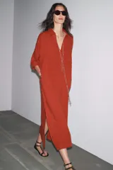 Vestido tipo túnica color ladrillo confeccionado en lino 100%. Tiene cuello solapa, escote pico, manga corta, bolsillos laterales ocultos y bolsillo de parche en el pecho. El bajo tiene aberturas laterales.