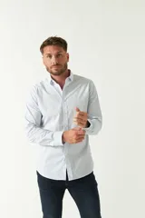 Camisa celeste a cuadros, de corte slim fit, manga larga y logo bordado. Confeccionada en 100% algodón.