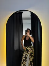 Pantalón de tiro alto color beige con estampado de manchas de vaca en marrón oscuro.