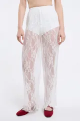 Pantalón de encaje blanco con cintura elastizada y lazo regulable.