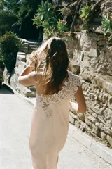 Vestido midi color beige, de viscosa, con escote asimétrico y detalle de crochet en el hombro.