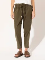 Pantalón babucha color verde militar, confeccionado en tejido de punto y plano. Tiene cintura elastizada con cordón ajustable y largo al tobillo.