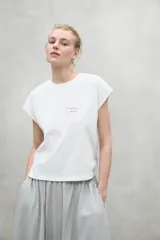 Camiseta blanca de manga corta con texto rojo "Because there is no planet B" en el frente.