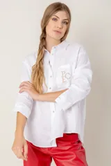 Camisa de lino color gris claro con bordado de monograma PEC en el bolsillo.