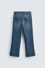 Pantalón de jean azul de tiro medio, corte flare, con cinco bolsillos y cierre frontal con cremallera y botón.