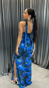 Vestido largo strapless con estampado abstracto en tonos azules y negros. Presenta un tajo lateral y un choker al tono.