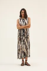 Vestido largo de corte recto con estampado tie-dye en tonos beige, marrón y negro. Tiene cuello redondo y sisas con ribete negro.