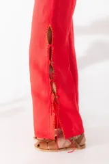 Pantalón negro de lino con aberturas laterales con cordones y bordado a contratono. Cuenta con un bolsillo trasero tejido a mano en crochet.