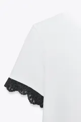 Camiseta blanca de algodón con cuello redondo y mangas cortas con detalle de encaje negro.