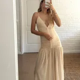 Vestido largo color amarillo pastel, con breteles finos y escote en V. La parte superior es de doble tela de microtul y la falda es amplia con volados.