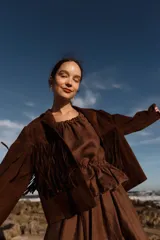 Chaqueta marrón de cuero gamuzado con flecos en la parte delantera y trasera.