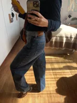 Pantalón de jean gris de corte recto y tiro medio, con bordado de estrella de ocho puntas en los bolsillos traseros.