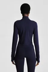 Campera deportiva corta color azul marino, de corte ajustado, cuello alto y cierre frontal. Confeccionada en tejido funcional SoftMove™ y DryMove™, mangas largas con abertura para el pulgar.