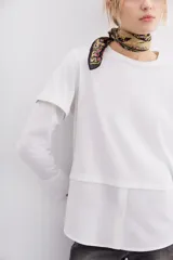 Remera blanca de algodón con mangas largas y calce recto. Diseño de doble capa, con remera de mangas rebatidas y camisa clásica debajo.
