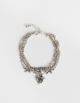Set de tres pulseras plateadas con diferentes cadenas de eslabones y dijes de corazones y moños.