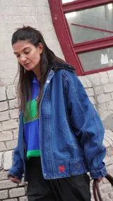 Campera de jean azul con corte oversize, solapa de corderito y pin decorativo.