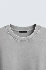 Camiseta azul marino de corte holgado, confeccionada en algodón con cuello redondo y mangas cortas. Presenta un efecto de lavado que le da una apariencia única.