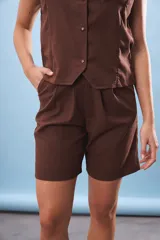 Bermuda marrón de corte clásico con pinzas y bolsillos laterales.