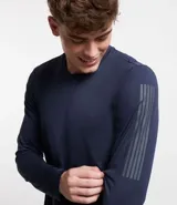 Remera deportiva de manga larga color azul marino, con cuello redondo y detalles reflectantes en franjas verticales en la parte superior del brazo.