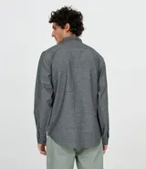 Camisa de manga larga gris con textura, cierre con botones, cuello clásico y bolsillo en el pecho.