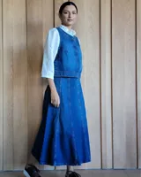 Pollera larga de denim color celeste, con diseño acampanado y costuras visibles.
