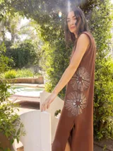 Vestido largo marrón sin mangas con bordado de dos flores grandes en el frente y aberturas laterales.