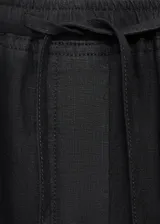 Pantalón negro de lino con cintura elástica y cordón ajustable.