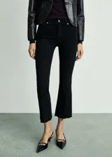 Pantalón de jeans negro de tiro alto, corte flare y bajo deshilachado.