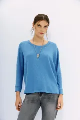 Remera de manga larga color terracota con textura jaspeada, confeccionada en algodón peruano. Presenta un calce holgado con mangas que se ensanchan debajo del brazo y se ajustan en la muñeca.