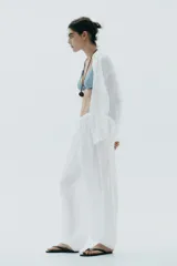 Pantalón bombacho de algodón blanco, con tiro medio, cintura elástica ajustable con cordones y bajo abullonado con elástico.